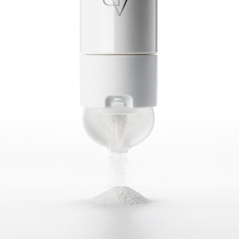White powder being dispensed from a container on a white background