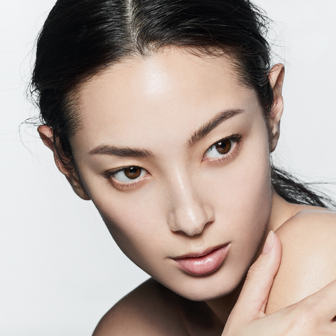 Close-up of a woman with a neutral expression on a white background
