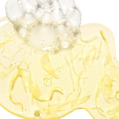 Close-up of a yellow gel-like substance with bubbles on a white background