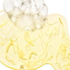 Close-up of a yellow gel-like substance with bubbles on a white background