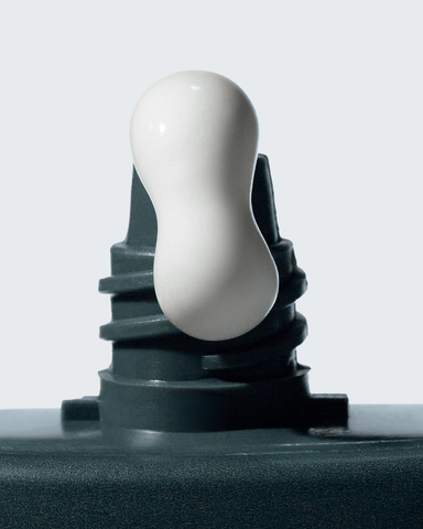 White plastic component on a black mechanical part against a light gray background