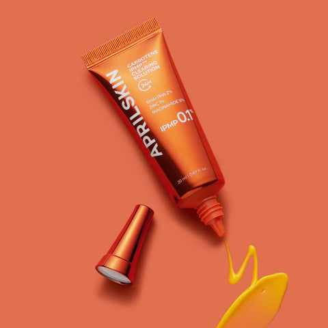 April Skin cosmetic tube on an orange background
