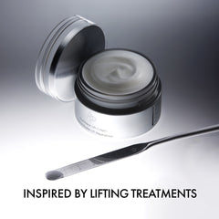 Skincare cream jar with a spoon on a gray background, labeled 'Inspired by Lifting Treatments'.