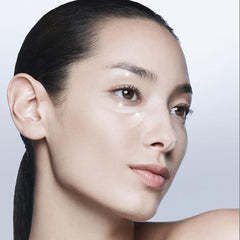 Close-up of a person with minimal makeup on a plain background