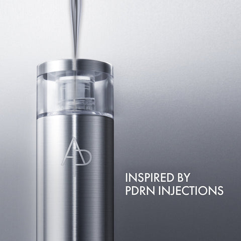 Silver skincare serum bottle with 'AD' logo on a gray background