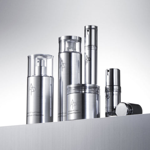 Set of silver skincare bottles with a brand logo on a gray background