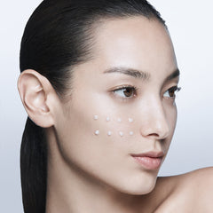 Woman with dots on her face against a plain background