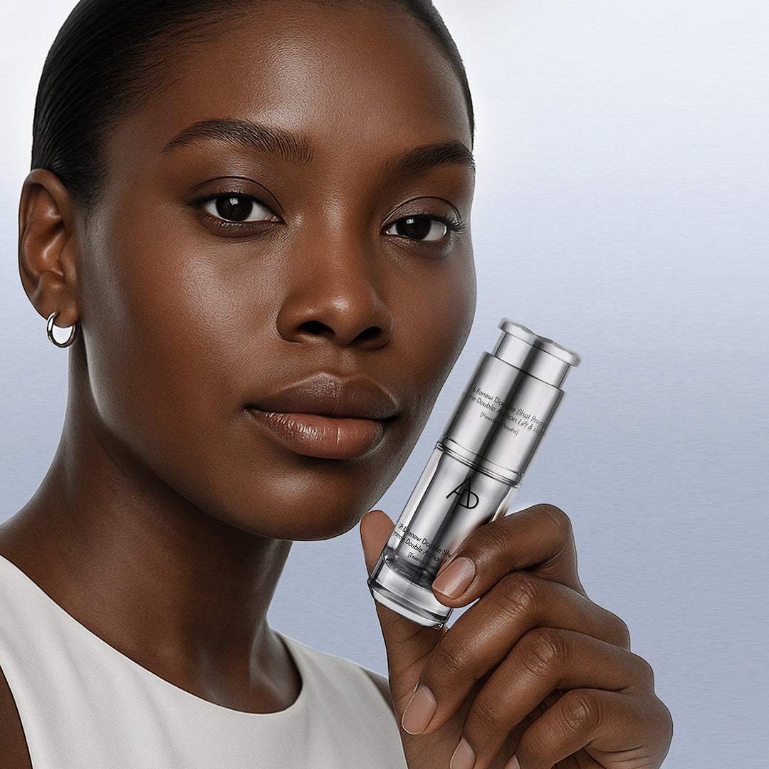 Woman holding a skincare product against a neutral background