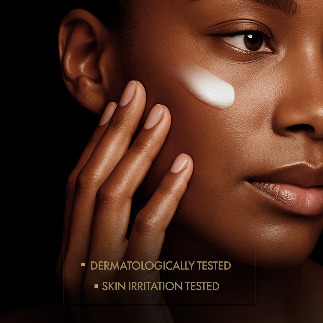 Close-up of a person applying cream to their face with a dark background