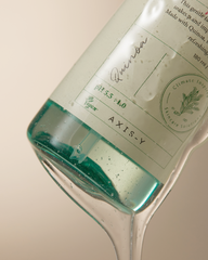 Bottle of Axis-Y gin with a label on a beige background