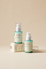 Two skincare bottles with a box on a beige background