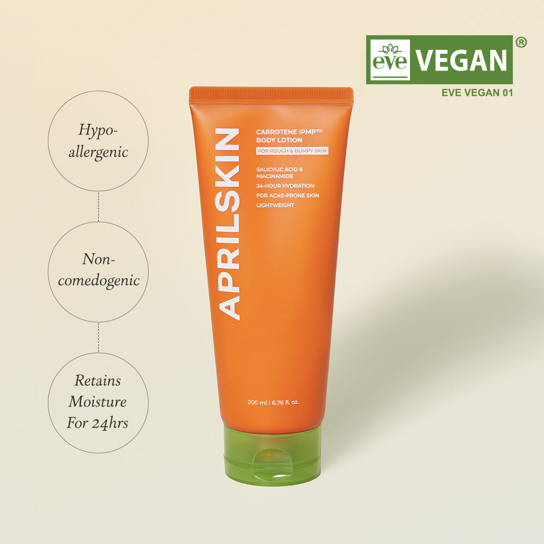 Orange tube of AprilSkin body lotion with green cap on a beige background, featuring 'Vegan' label.