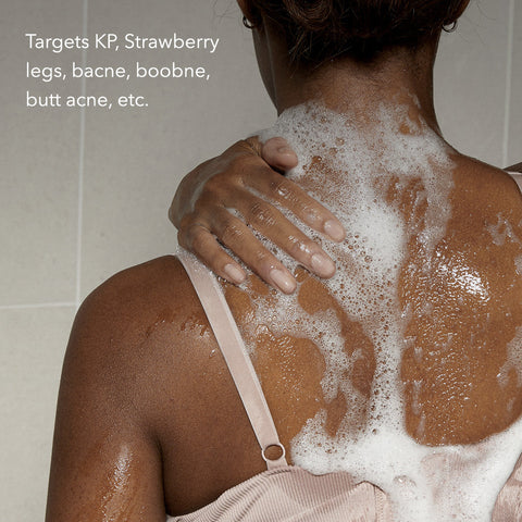 Person with soap suds on their back in a shower setting