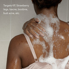 Person with soap suds on their back in a shower setting