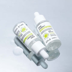 Two skincare droppers with visible branding on a light gray background
