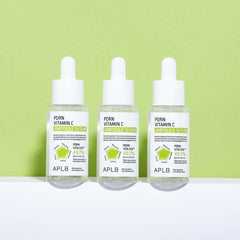Three bottles of APLB Porn Vitamin C Ampoule Serum on a white surface with a green background