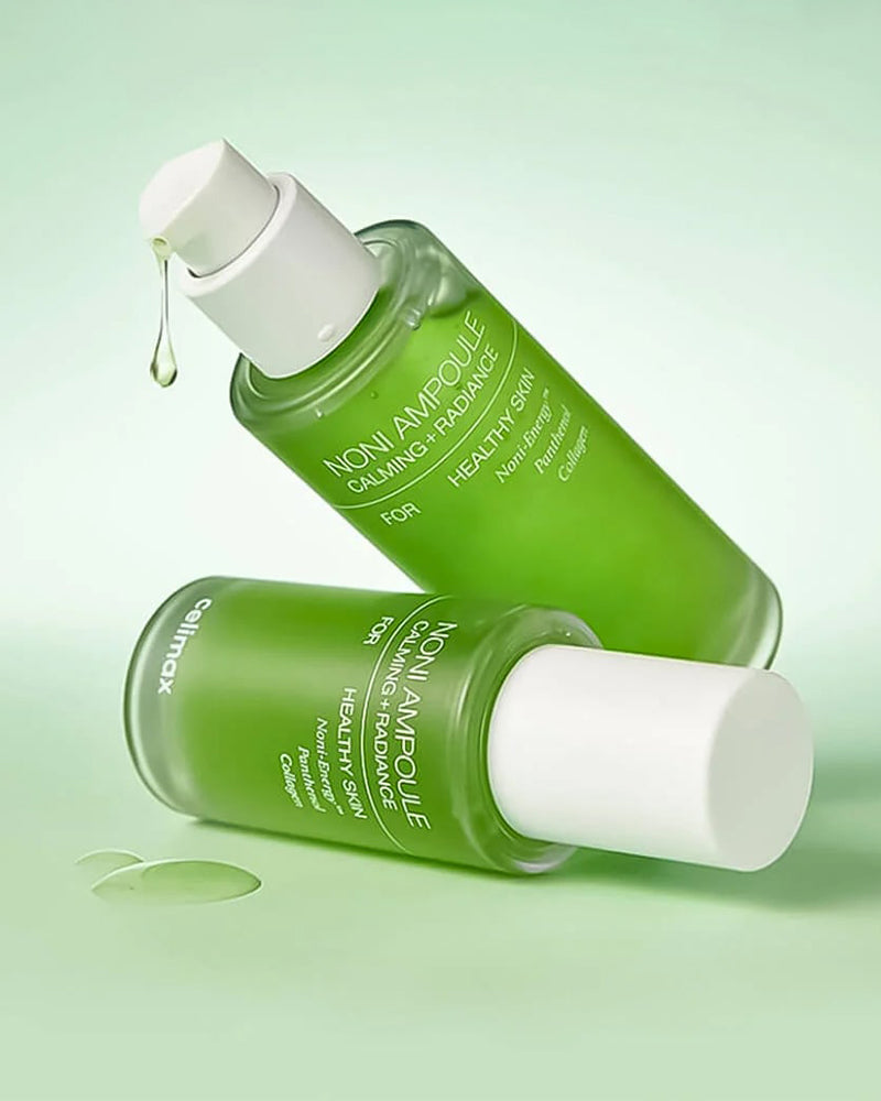 Two green skincare bottles with white caps on a light green background