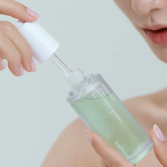 Person holding a skincare bottle with a dropper, featuring the brand 'celimax'.