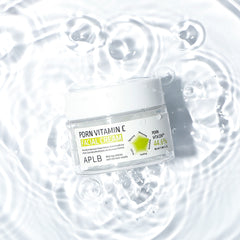 Jar of facial cream with 'PORN VITAMIN C' on a water surface
