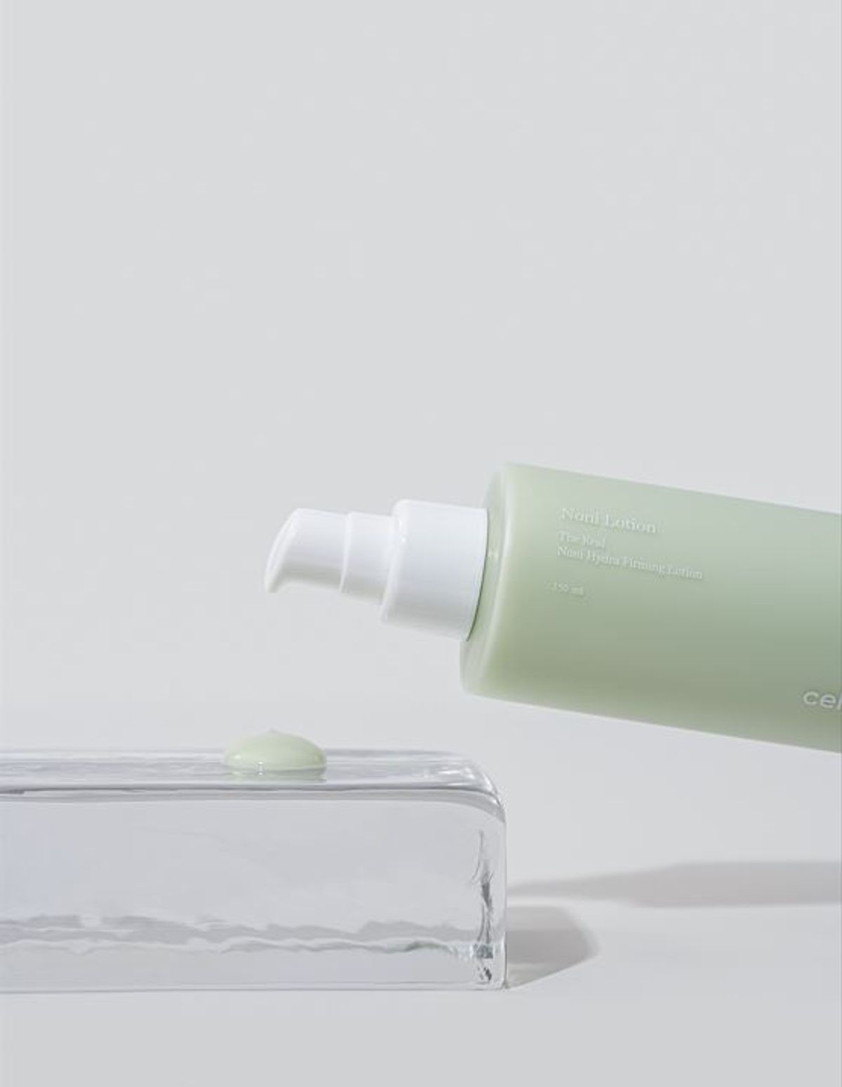 Green skincare product with pump on a white background