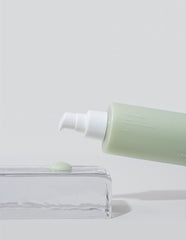 Green skincare product with pump on a white background