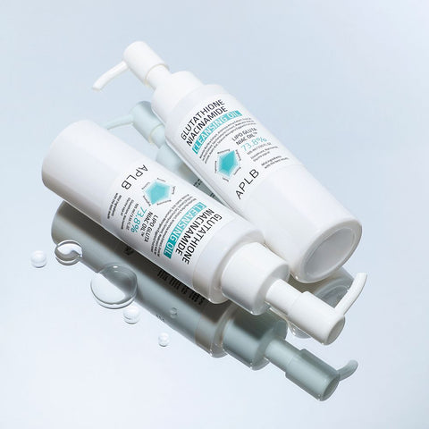 Two skincare bottles with pump dispensers on a light blue background