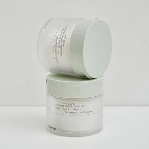 Two skincare containers with labels on a light gray background